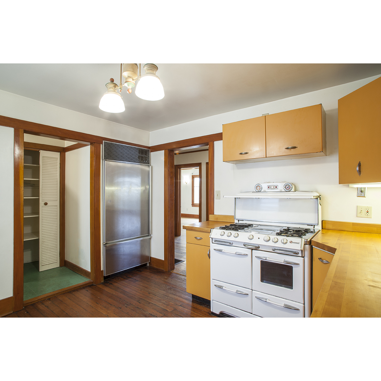 Vintage Los Angeles kitchen with original orange cabinetry and white stove